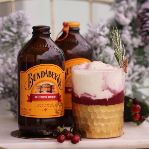 Snowy Evening Float Cocktail with Bundaberg Ginger Beer garnished with a sprig of rosemary, ice cream and cranberry