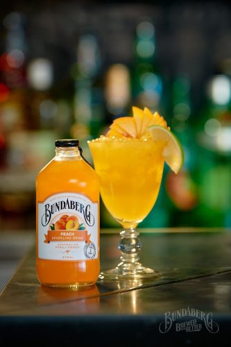 The Amber Peach Mocktail with Bundaberg Peach garnished with peach fan and lime wedge